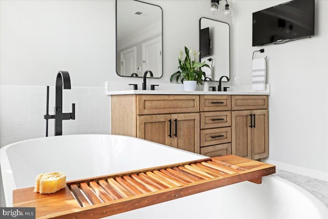 bathroom featuring vanity, tasteful backsplash, and a tub