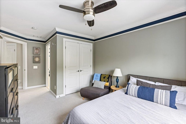 carpeted bedroom with a closet, ceiling fan, and ornamental molding