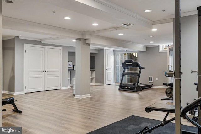 exercise area featuring ornamental molding and light hardwood / wood-style flooring