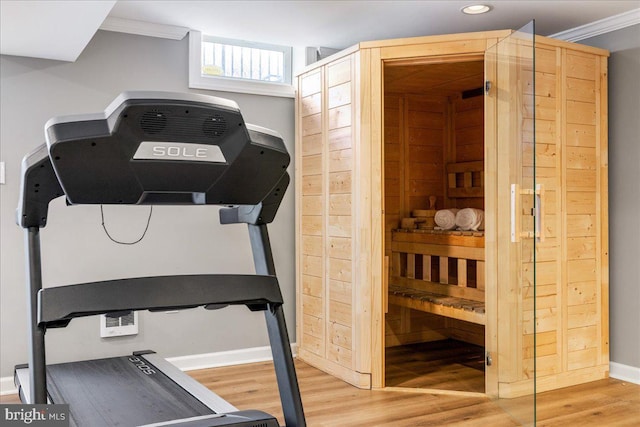 workout room with ornamental molding and hardwood / wood-style floors