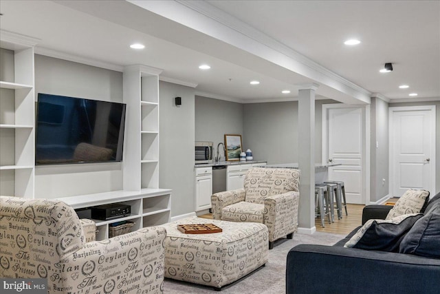 living room with sink, ornamental molding, and light hardwood / wood-style floors