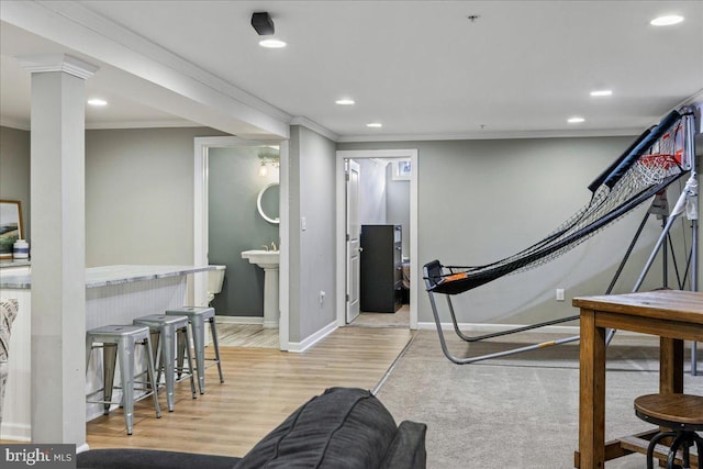 workout area featuring light hardwood / wood-style flooring and crown molding