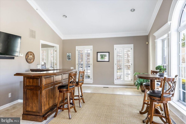 bar with light tile patterned flooring, vaulted ceiling, and crown molding