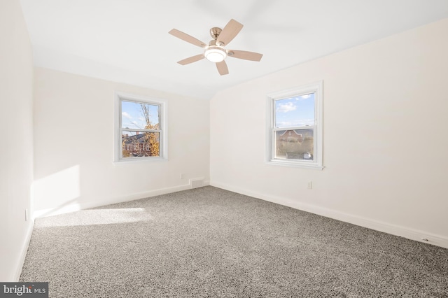 spare room with carpet floors, a wealth of natural light, and baseboards