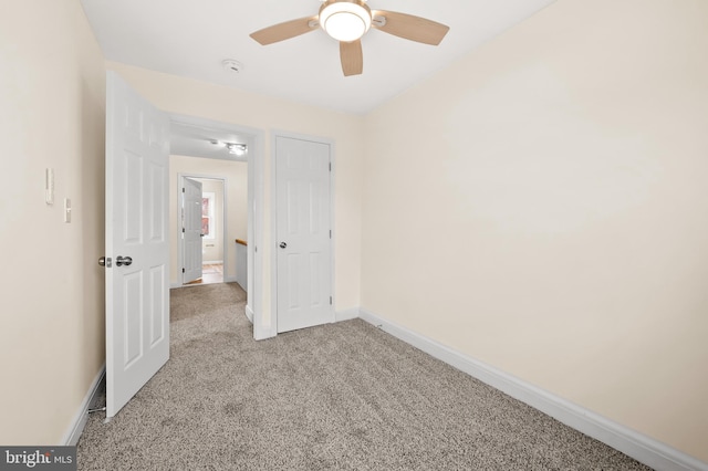 unfurnished bedroom with a ceiling fan, baseboards, and carpet flooring