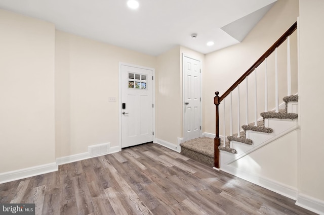 foyer with baseboards, visible vents, wood finished floors, stairs, and recessed lighting