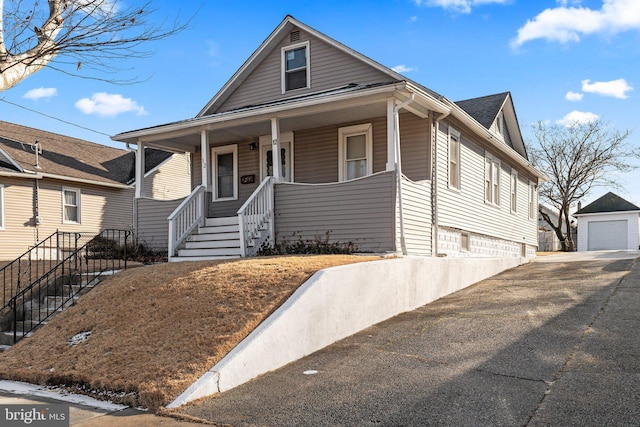 view of front of home featuring an outbuilding, covered porch, and a garage