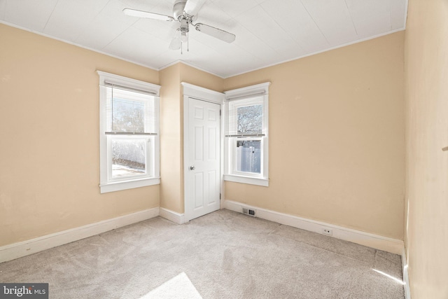 unfurnished bedroom featuring light carpet, ceiling fan, ornamental molding, and a closet