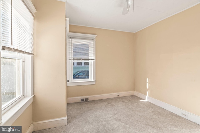 empty room with light carpet, ceiling fan, and ornamental molding