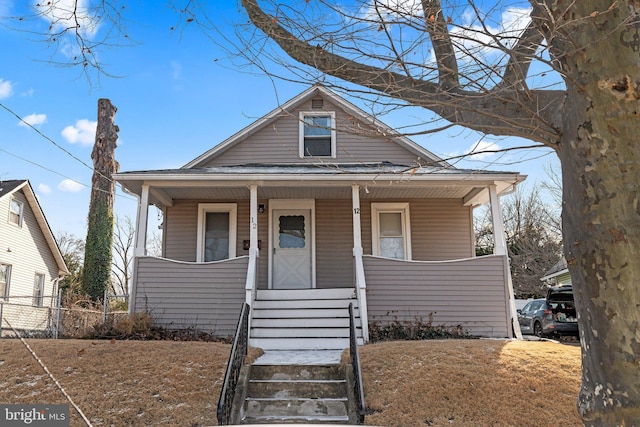 bungalow-style house with a front lawn and covered porch