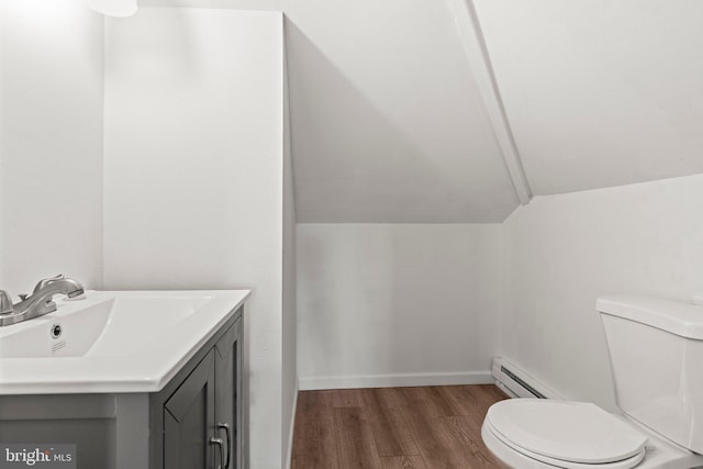 bathroom featuring toilet, a baseboard radiator, wood-type flooring, vaulted ceiling, and vanity