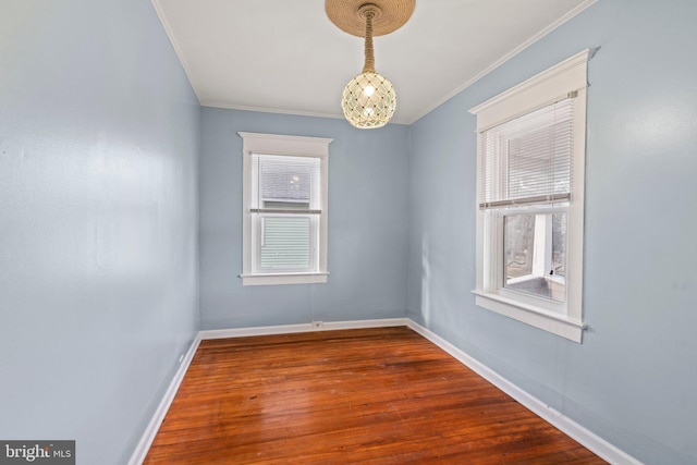 spare room with ornamental molding, hardwood / wood-style floors, and a notable chandelier