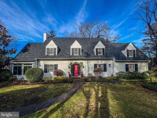 cape cod house featuring a front yard