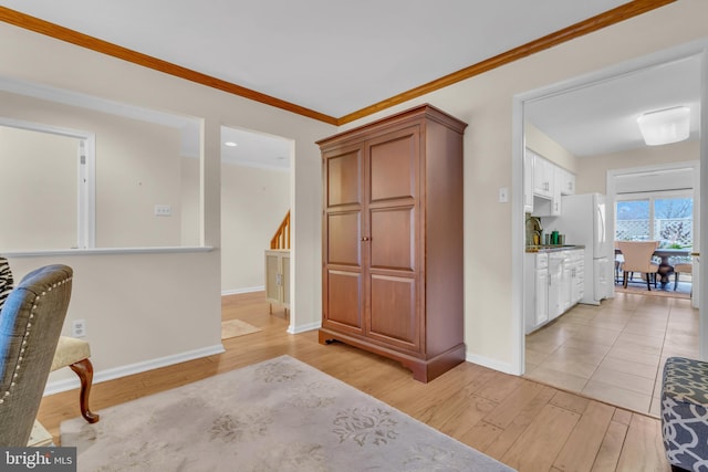 interior space with white cabinets, light hardwood / wood-style flooring, crown molding, and white refrigerator