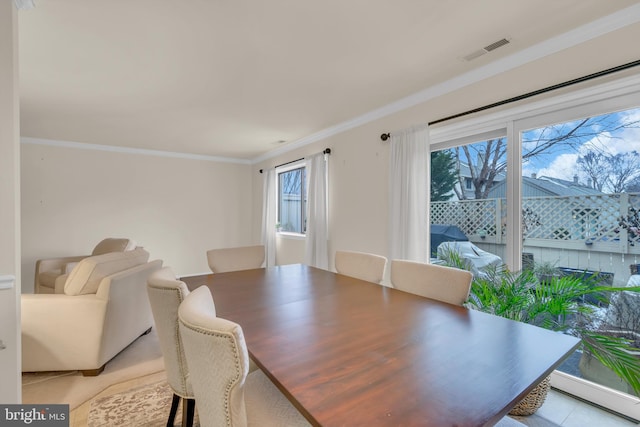 dining area featuring light tile patterned floors and ornamental molding