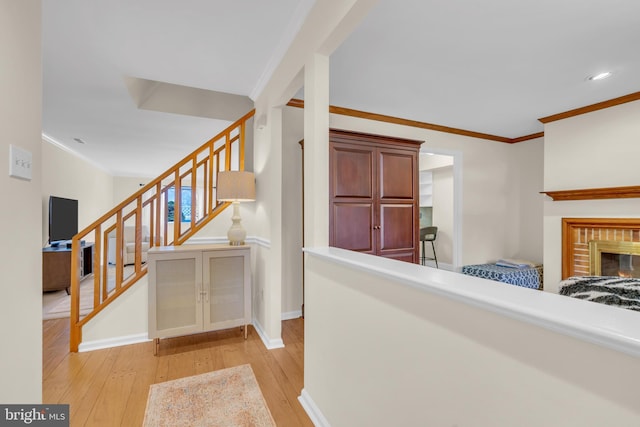 hall with crown molding and light hardwood / wood-style flooring