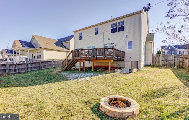 back of house featuring an outdoor fire pit, a yard, and a wooden deck