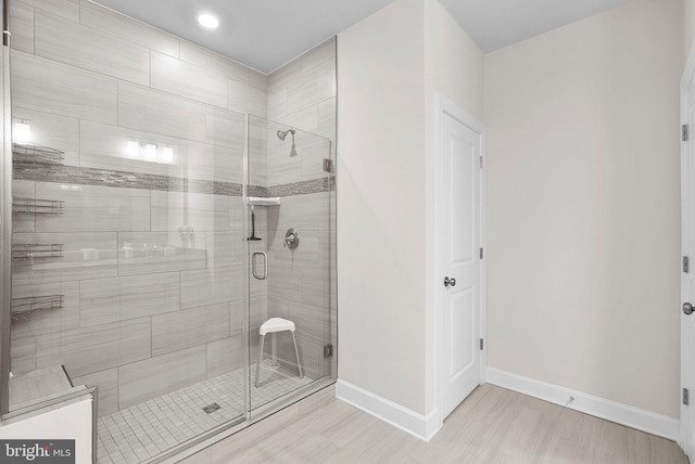 bathroom featuring a shower with door