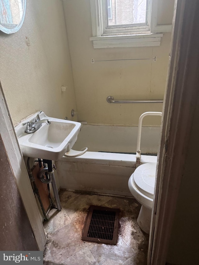 bathroom with toilet, a bathing tub, and sink