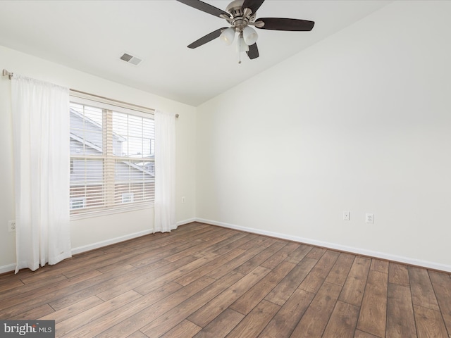 empty room with ceiling fan, vaulted ceiling, and wood-type flooring