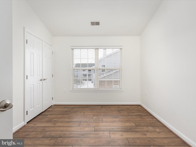 spare room featuring dark wood-type flooring