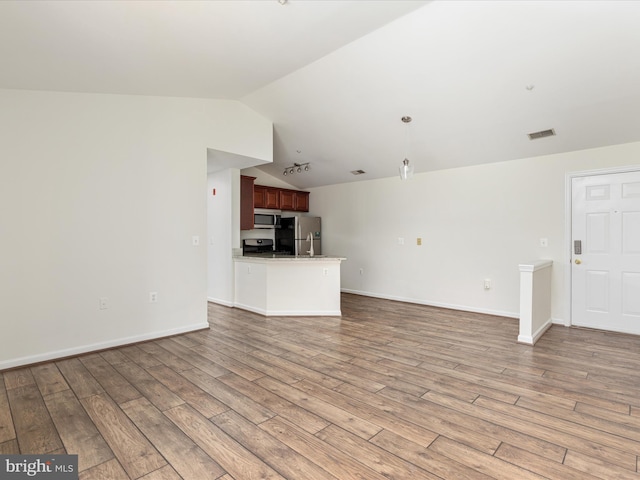 unfurnished living room featuring hardwood / wood-style floors and vaulted ceiling