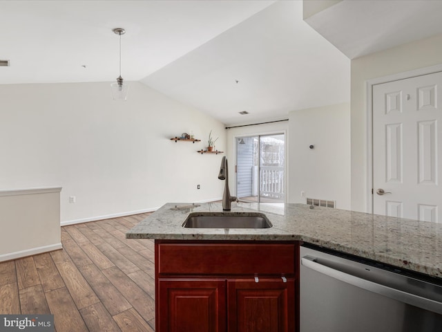 kitchen featuring sink, lofted ceiling, light wood-type flooring, stainless steel dishwasher, and hanging light fixtures