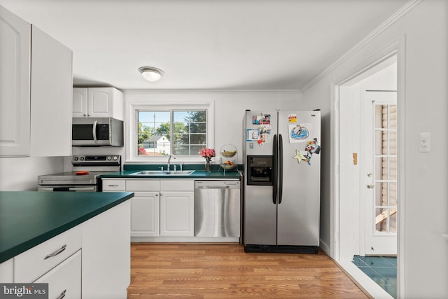 kitchen featuring white cabinetry, sink, light hardwood / wood-style flooring, appliances with stainless steel finishes, and ornamental molding