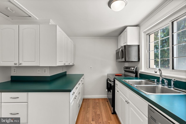 kitchen with a wealth of natural light, white cabinetry, sink, and appliances with stainless steel finishes