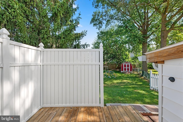 view of gate with a lawn and a storage shed