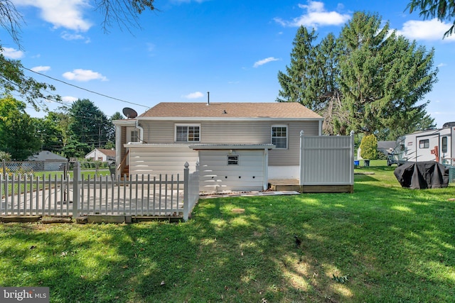 rear view of property featuring a yard and a wooden deck