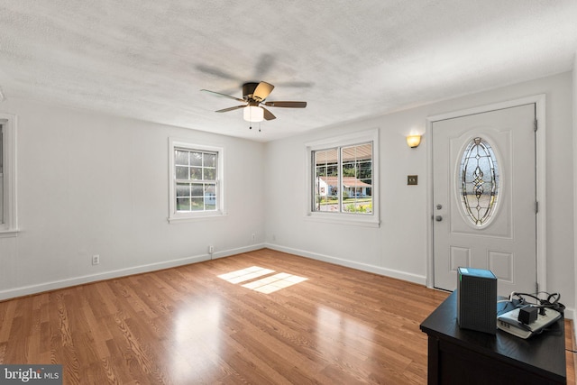 entryway featuring plenty of natural light, ceiling fan, a textured ceiling, and light hardwood / wood-style flooring