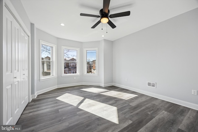 unfurnished bedroom featuring dark wood-type flooring, ceiling fan, and a closet