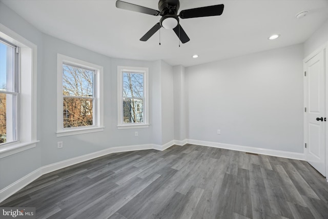 empty room with dark hardwood / wood-style floors and ceiling fan