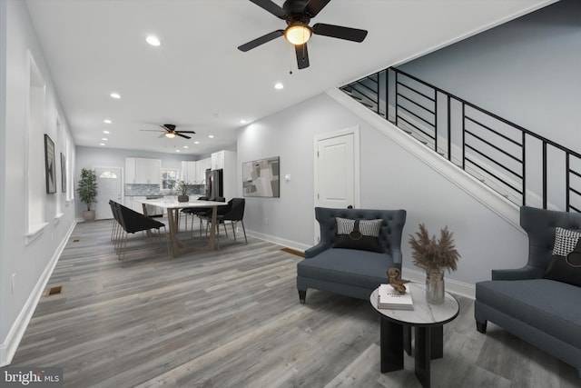 living room with ceiling fan and light hardwood / wood-style floors