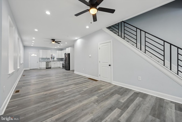 unfurnished living room with ceiling fan and light hardwood / wood-style floors