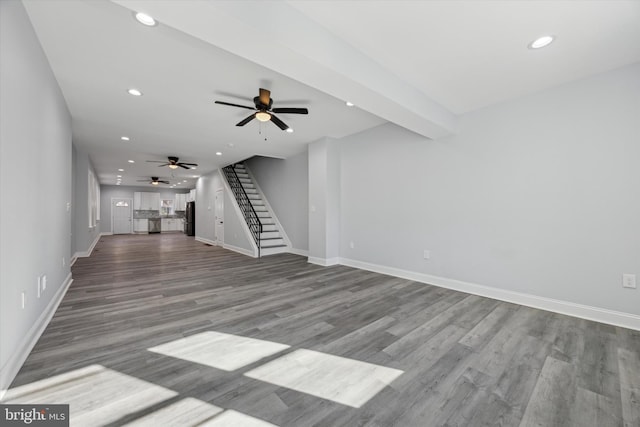 unfurnished living room with ceiling fan, wood-type flooring, and beamed ceiling