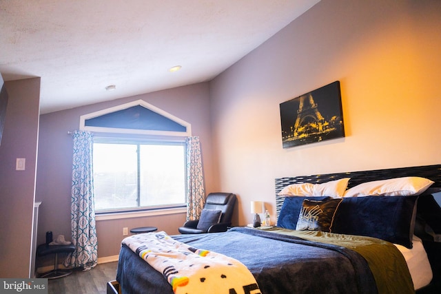 bedroom with wood-type flooring and vaulted ceiling