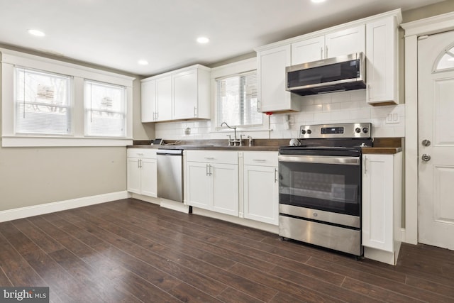 kitchen with stainless steel appliances, dark hardwood / wood-style flooring, white cabinetry, and tasteful backsplash