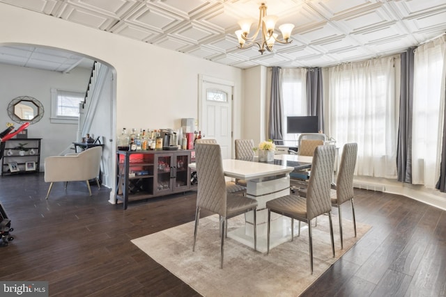 dining space with a healthy amount of sunlight, dark hardwood / wood-style flooring, and a chandelier