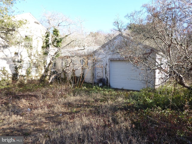 view of property exterior featuring a garage and an outbuilding