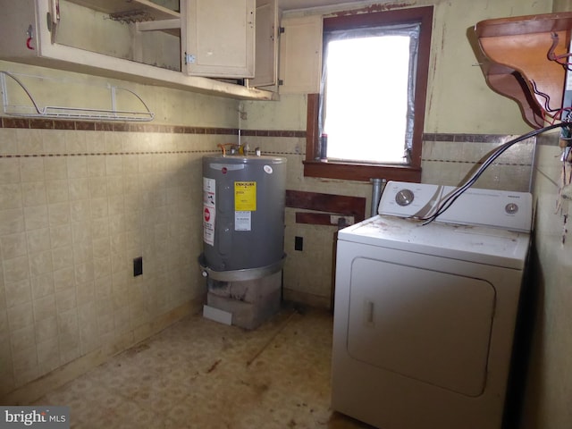 laundry room featuring washer / dryer, cabinets, and electric water heater