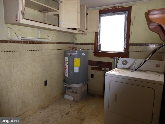 laundry room with electric water heater, tile walls, washer / dryer, and cabinets