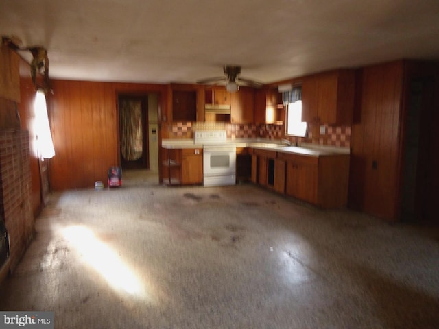 kitchen featuring ceiling fan, backsplash, white range, and sink