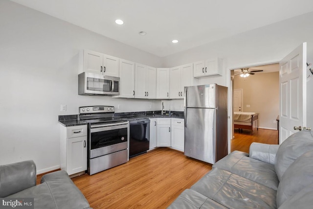 kitchen featuring sink, white cabinetry, light hardwood / wood-style flooring, and appliances with stainless steel finishes