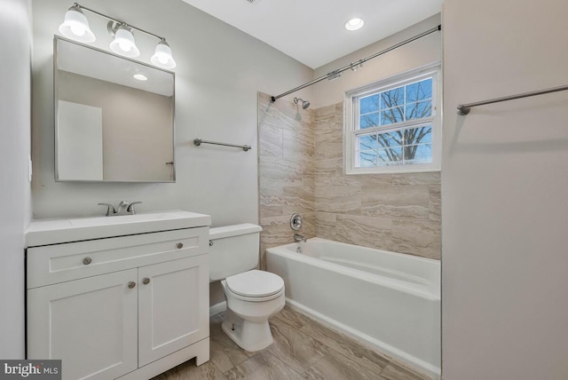 full bathroom with vanity, tiled shower / bath combo, and toilet