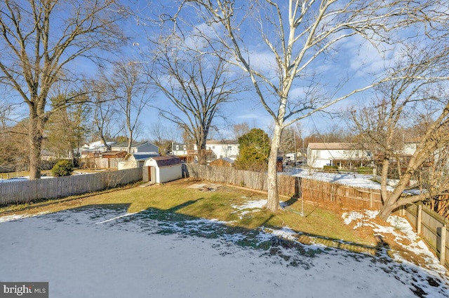 yard covered in snow featuring a storage shed