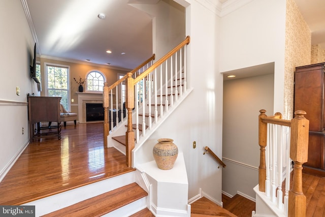 staircase featuring crown molding and hardwood / wood-style flooring