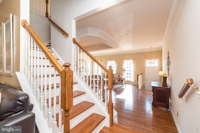 stairs featuring crown molding and hardwood / wood-style flooring