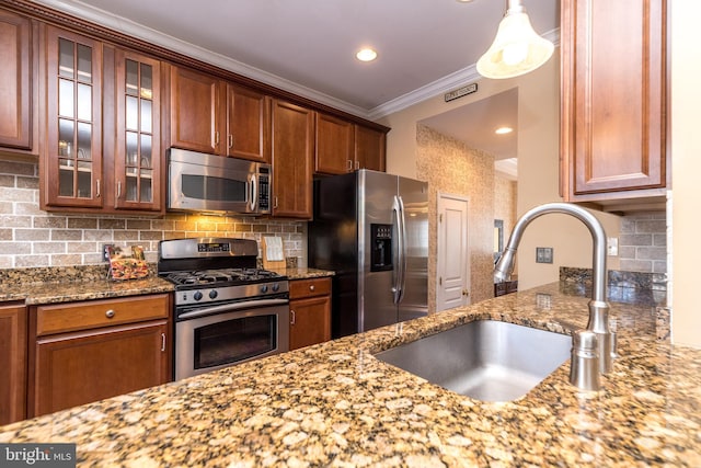 kitchen with sink, decorative backsplash, light stone countertops, and appliances with stainless steel finishes